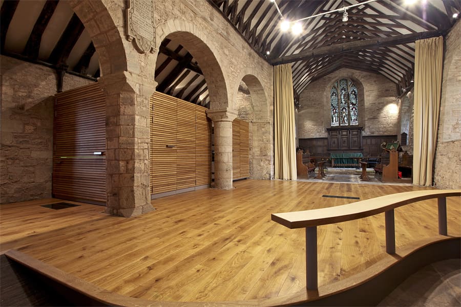 Interior of st Andrews, church re-ordering, a new timber floor has been added and in the back left is a timber cube behind pillars, this contains a kitchen and toilet facilities, unseen.