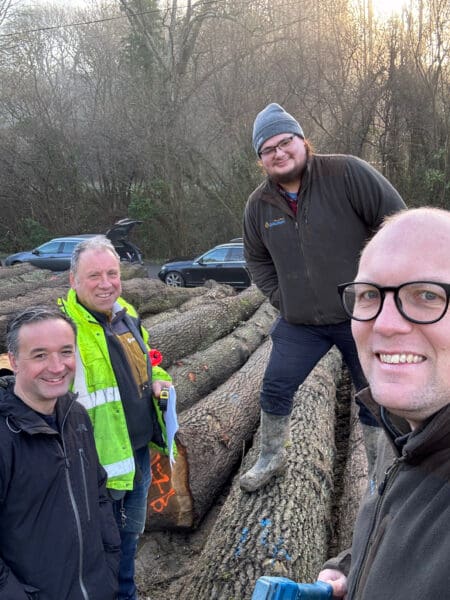 A group of four men viewing felled tree trunks. Communion Architects Hereford